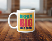 Mug with 'Dream Big Read Books' text on a wooden surface